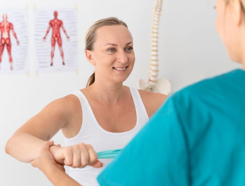 Patient practicing an arm exercise with a therapist