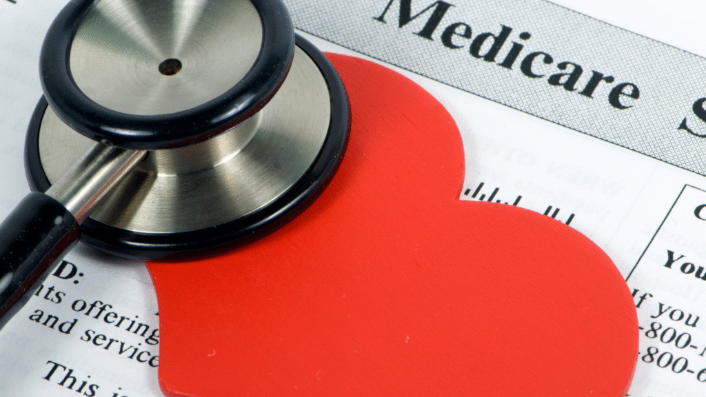 Close-up of a stethoscope and red heart on a Medicare insurance paper.